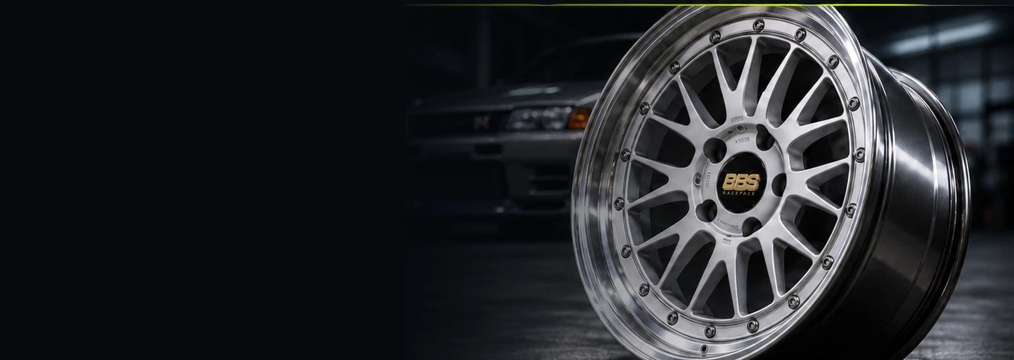Silver wheel against a dark garage and Skyline backdrop